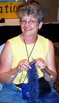 Another one who doesnt know that this is a BASKETRY convention.  Mary Wiggs knits up a scarf while volunteering at the registration table.